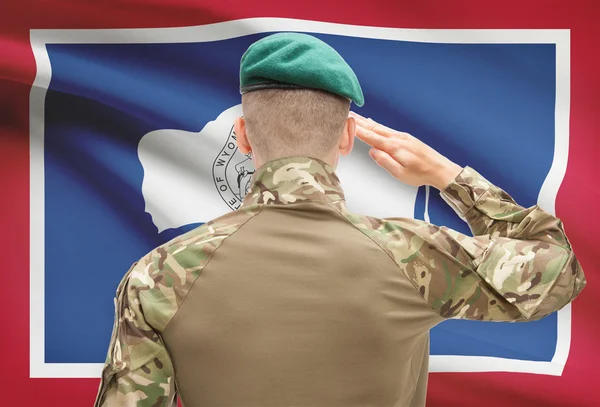 Soldier saluting to USA state flag conceptual series - Wyoming