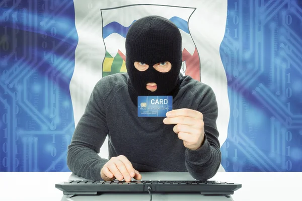Hacker holding credit card and Canadian province flag on background - Northwest Territories