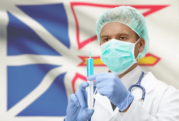 Doctor with syringe in hands and Canadian province flag on background series - Newfoundland and Labrador