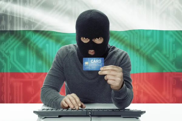 Dark-skinned hacker with flag on background holding credit card - Bulgaria