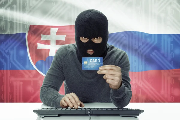 Dark-skinned hacker with flag on background holding credit card - Slovakia