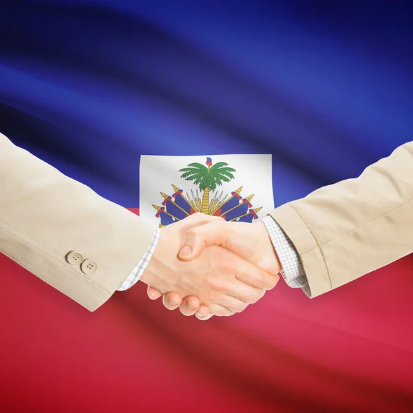 Businessmen handshake with flag on background - Haiti