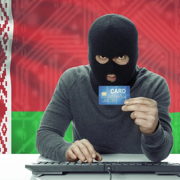 Dark-skinned hacker with flag on background holding credit card in hand - Belarus