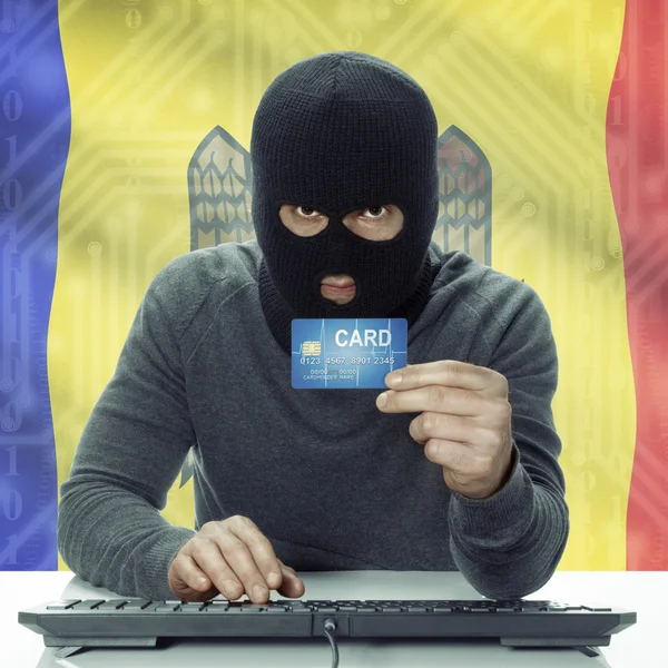 Dark-skinned hacker with flag on background holding credit card in hand - Moldova