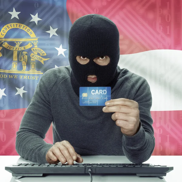 Dark-skinned hacker with USA states flag on background holding card in hand - Georgia