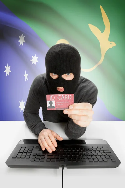 Hacker with flag on background holding ID card in hand - Christmas Island