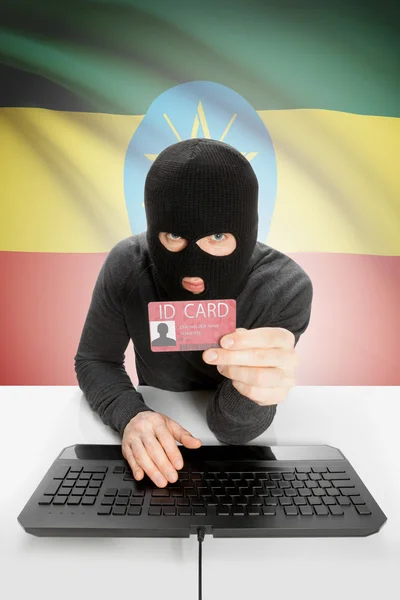 Hacker with flag on background holding ID card in hand - Ethiopia