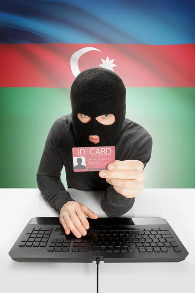 Hacker with flag on background holding ID card in hand - Azerbaijan