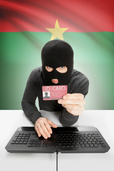 Hacker with flag on background holding ID card in hand - Burkina Faso