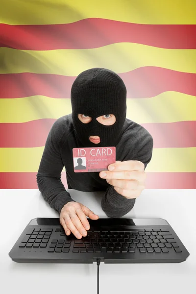 Hacker with flag on background holding ID card in hand - Catalonia