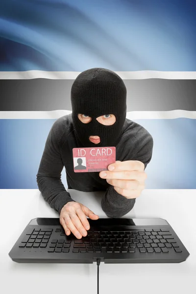 Hacker with flag on background holding ID card in hand - Botswana