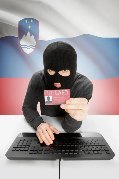 Hacker with flag on background holding ID card in hand - Slovenia