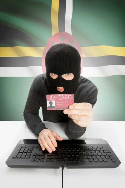 Hacker with flag on background holding ID card in hand - Dominica