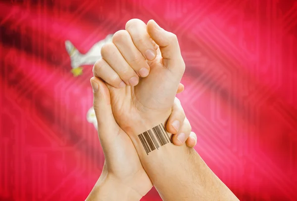 Barcode ID number on wrist and national flag on background - Isle of Man