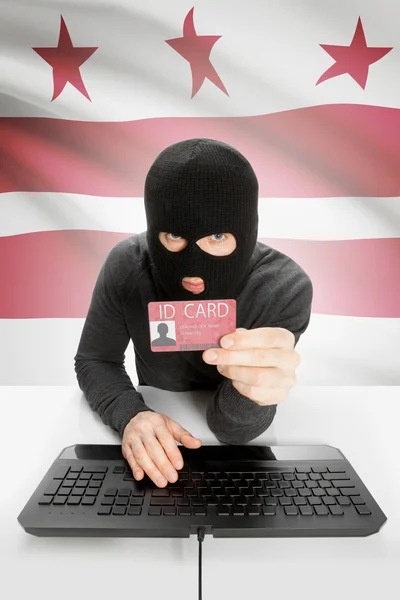 Hacker with USA states flag on background and ID card in hand - District of Columbia