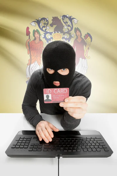 Hacker with USA states flag on background and ID card in hand - New Jersey