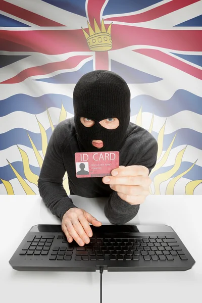 Hacker with Canadian province flag on background holding ID card in hand - British Columbia
