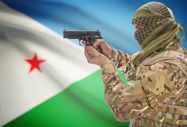 Male in muslim keffiyeh with gun in hand and national flag on background - Djibouti