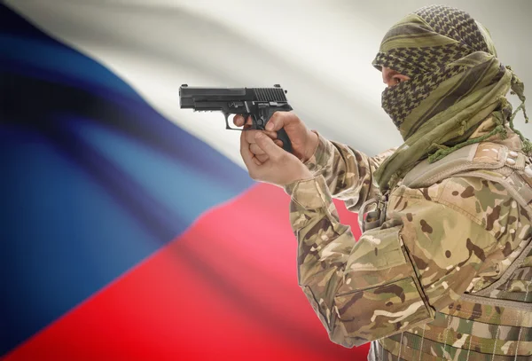 Male in muslim keffiyeh with gun in hand and national flag on background - Czech Republic