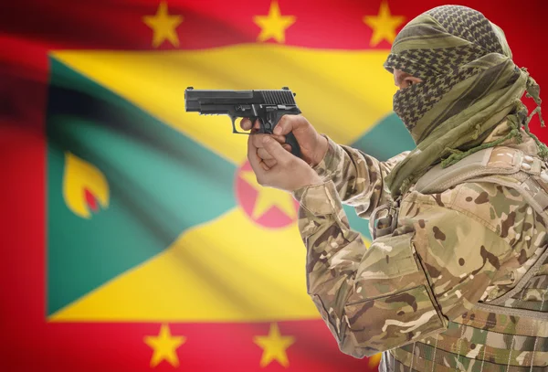 Male in muslim keffiyeh with gun in hand and national flag on background - Grenada
