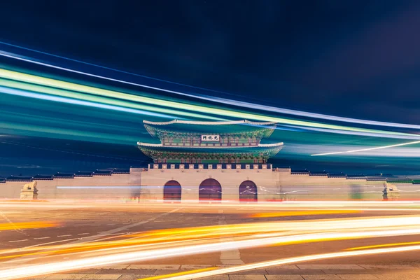 Gwanghwamun gate of Gyeongbokgung Palace in Seoul, South Korea with taillights and headlights of cars in front of it