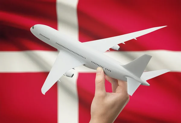 Airplane in hand with flag on background - Denmark