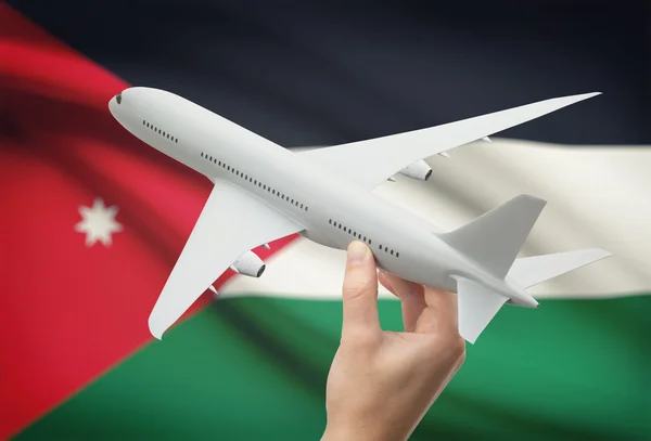 Airplane in hand with flag on background - Jordan