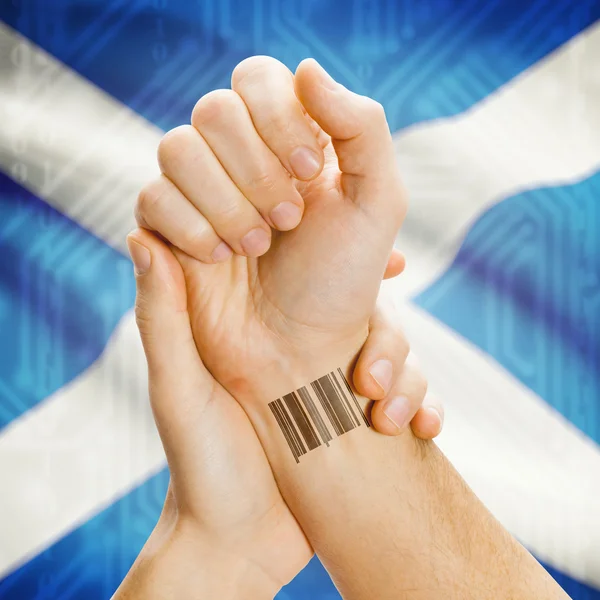 Barcode ID number on wrist and national flag on background series - Scotland