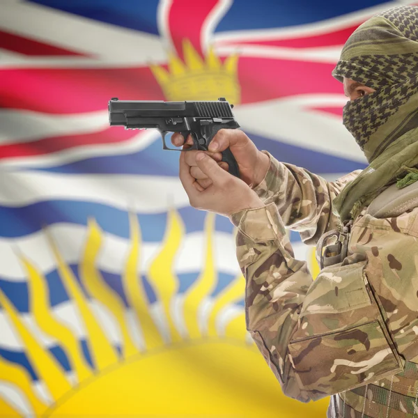 Man with gun in hand and Canadian province flad on background - British Columbia