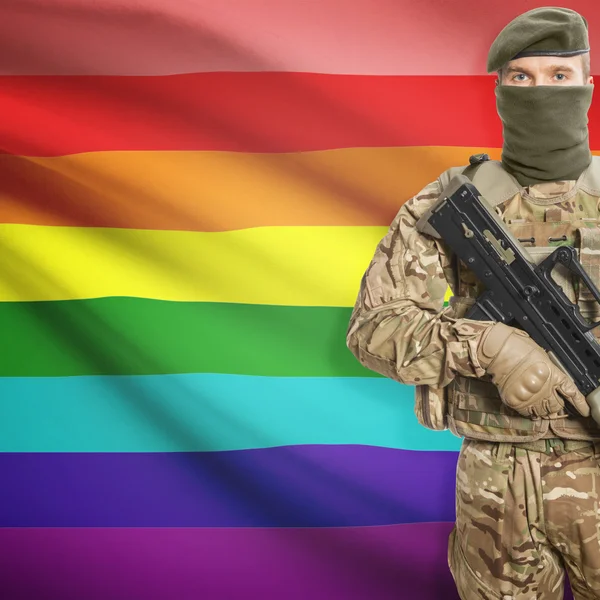 Soldier with machine gun and flag on background - LGBT people