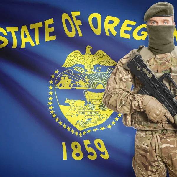 Soldier with machine gun and USA state flag on background - Oregon