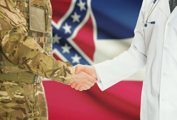 Military man in uniform and doctor shaking hands with US states flags on background - Mississippi