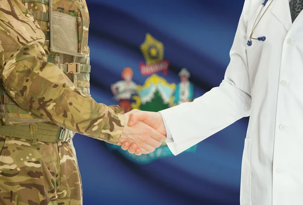 Military man in uniform and doctor shaking hands with US states flags on background - Maine