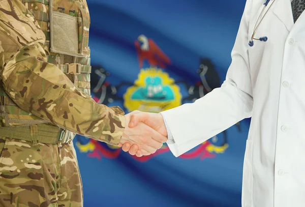 Military man in uniform and doctor shaking hands with US states flags on background - Pennsylvania