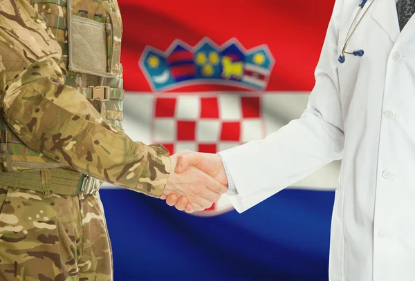 Military man in uniform and doctor shaking hands with national flag on background - Croatia