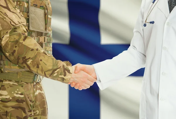 Military man in uniform and doctor shaking hands with national flag on background - Finland