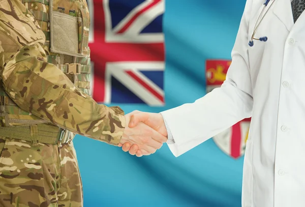 Military man in uniform and doctor shaking hands with national flag on background - Fiji