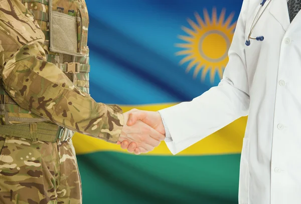 Military man in uniform and doctor shaking hands with national flag on background - Rwanda