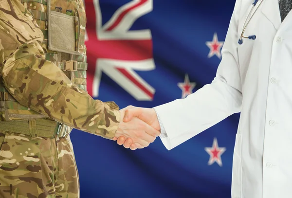 Military man in uniform and doctor shaking hands with national flag on background - New Zealand