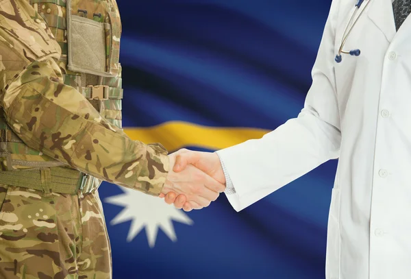 Military man in uniform and doctor shaking hands with national flag on background - Nauru