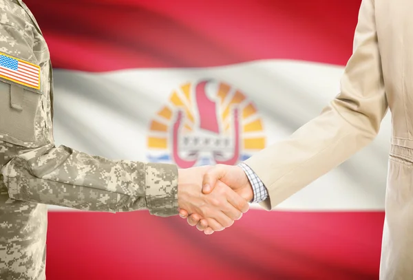 USA military man in uniform and civil man in suit shaking hands with national flag on background - French Polynesia