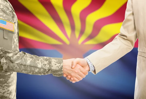 USA military man in uniform and civil man in suit shaking hands with USA state flag on background - Arizona