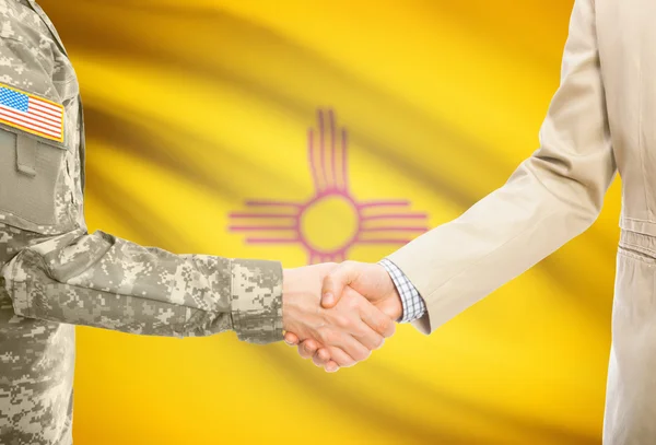 USA military man in uniform and civil man in suit shaking hands with USA state flag on background - New Mexico