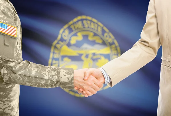 USA military man in uniform and civil man in suit shaking hands with USA state flag on background - Nebraska