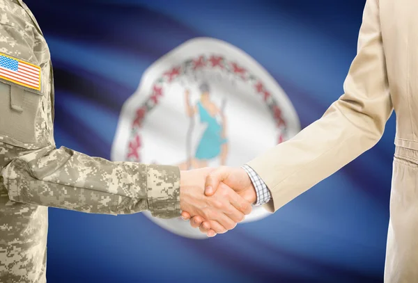 USA military man in uniform and civil man in suit shaking hands with USA state flag on background - Virginia