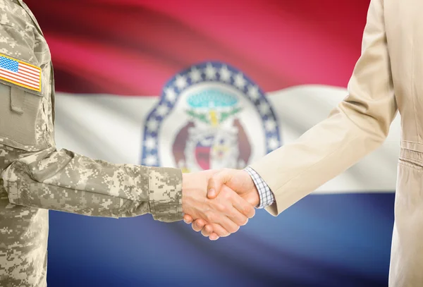 USA military man in uniform and civil man in suit shaking hands with USA state flag on background - Missouri