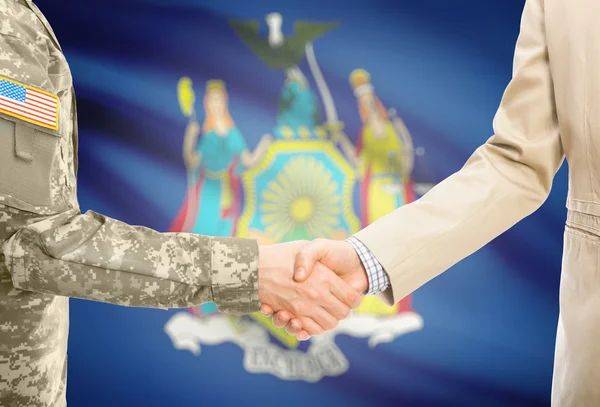 USA military man in uniform and civil man in suit shaking hands with USA state flag on background - New York