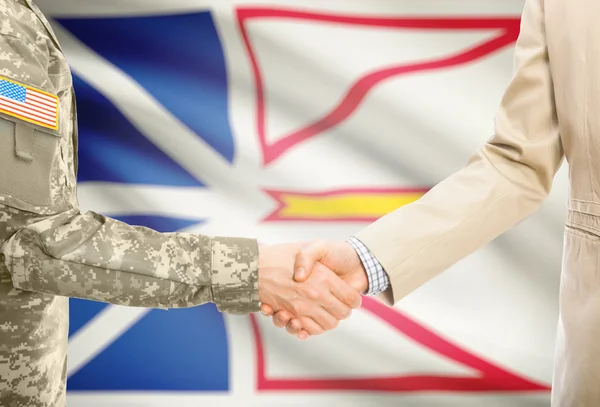 USA military man in uniform and civil man in suit shaking hands with Canadian province flag on background - Newfoundland and Labrador