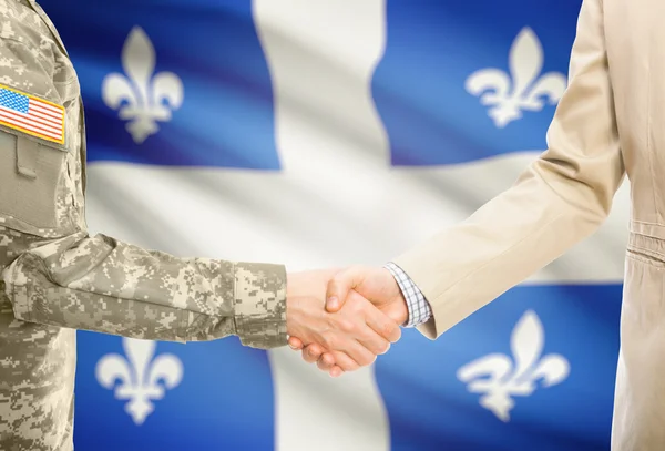 USA military man in uniform and civil man in suit shaking hands with Canadian province flag on background - Quebec