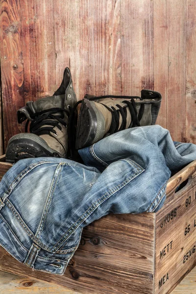 Old Boots and jeans over wooden background